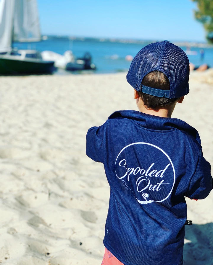 Young boy with Spooled Out Australia shirt standing on a beach