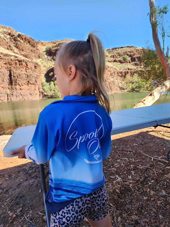 Young girl wearing Spooled Out Australia shirt near a fishing spot